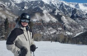 Showing me dressed in winter clothing, helmet and goggles, skiing at the Telluride Ski Area.